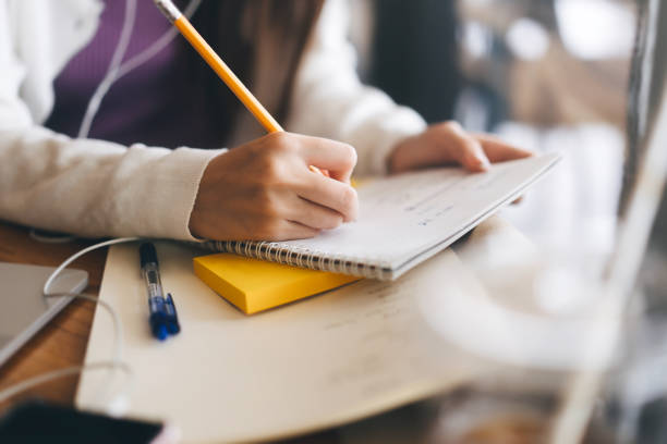 istock Closeup hand young adult women writing note for study and work online. 1299195168