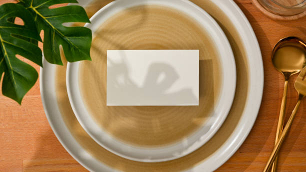 istock Dining set with mock up name card on mock up ceramic plate and brass spoon and fork 1299198497