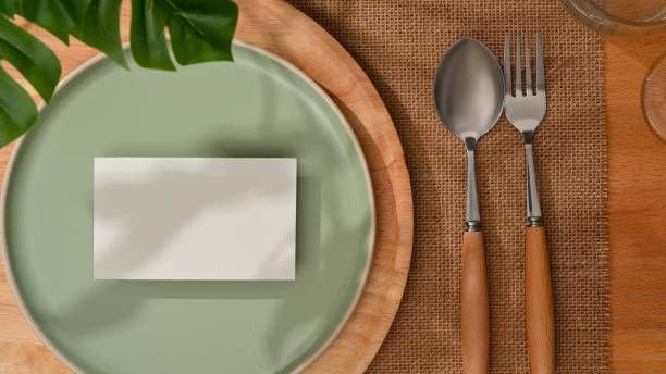 istock Top view of mock up card on mock up ceramic plate and silverware on dining table 1299198520