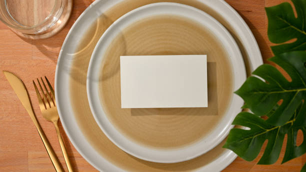istock Dining set with mock up name card on mock up ceramic plate and brass fork and table knife 1299198542