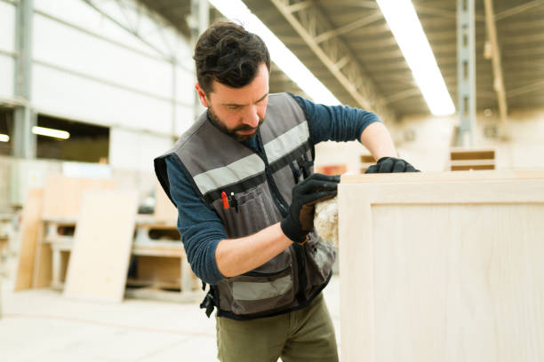 istock Hispanic carpenter working with wood oil stain 1299201558