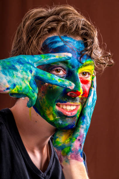 istock Teenage boy experiments with face/body paint in preparation for a school project. 1299203159