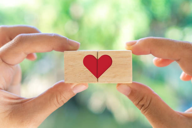 istock Hand hold wooden cube with heart sign icon on and copy space nature sunlight you can put text on background. Valentine love season concept. 1299204366