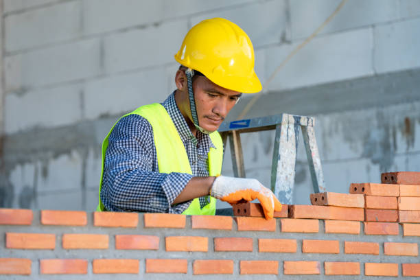 Construction worker installing red brick with trowel putty knife for new house building. Brick mason,Construction worker installing red brick with trowel putty knife for new house building at construction site. hand with a plaster spatula stock pictures, royalty-free photos & images