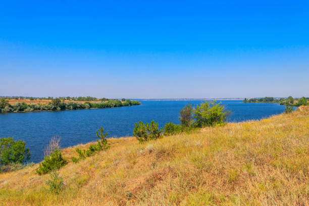 istock Summer landscape with beautiful river, green trees and blue sky 1299215818