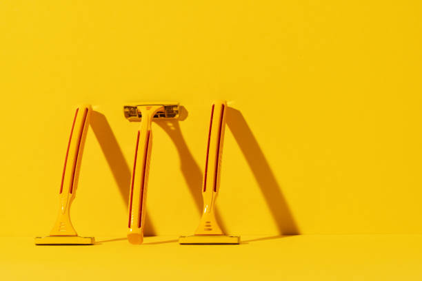 istock Disposable razors on yellow background, studio shot 1299217658