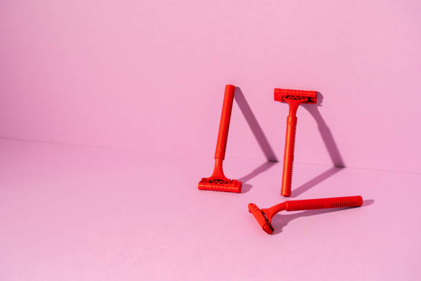 istock Red disposable razor on pink background, copy space 1299218560