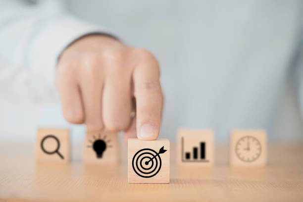 businessman pushing target dartboard icon in front of others icons to setup business objectives. - performance efficiency business determination imagens e fotografias de stock