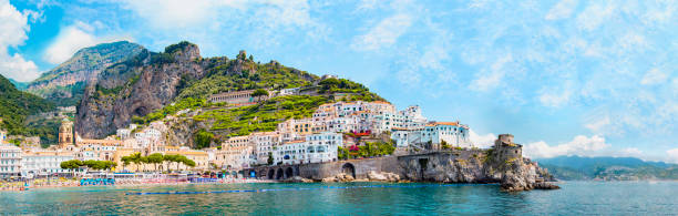 vista panoramica, skyline aereo di un piccolo paradiso del villaggio di amalfi con piccola spiaggia e case colorate situate sulla roccia. cime delle montagne in costiera amalfitana, salerno, campania, italia - salerno foto e immagini stock