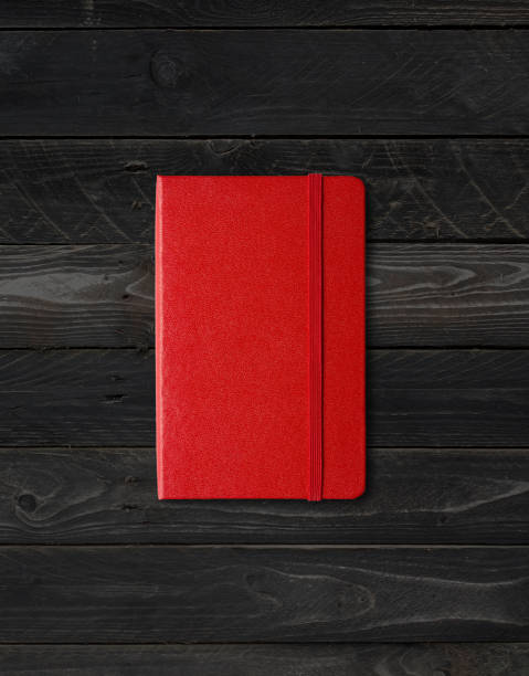 istock Red closed notebook on black wood background 1299222259