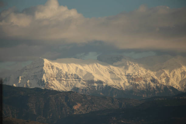 mountain pick with snow and sun  on top clouds ice winter background in mitsikeli mountain grreece