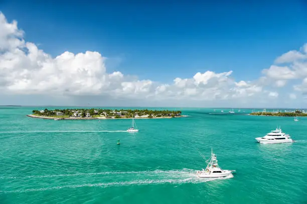 Photo of touristic yachts floating by green island at Key West, Florida