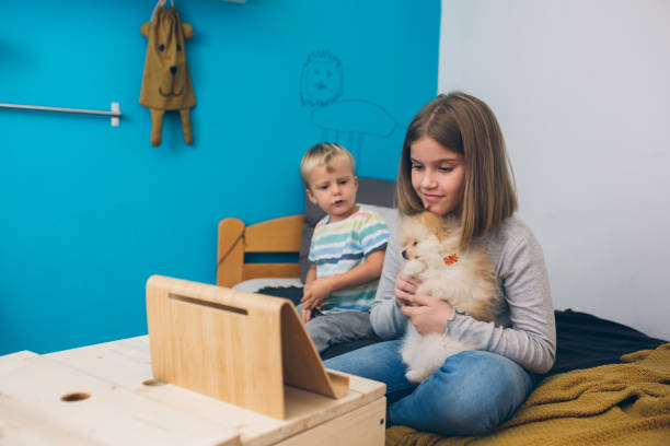istock brother and sister  playing with their puppy 1299223264