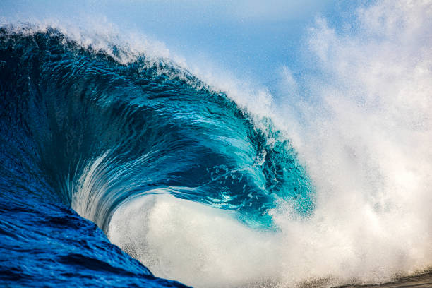 istock Powerful blue and aquamarine wave breaking in the open ocean on a sunny day 1299225242