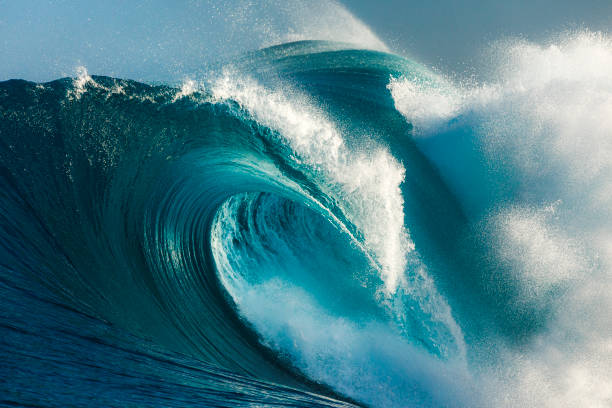 istock Powerful blue and aquamarine wave breaking in the open ocean on a sunny day 1299226322