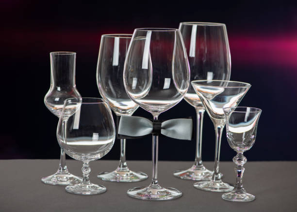 istock Glasses with bow tie isolated on black background. World Bartender Day. 1299226615