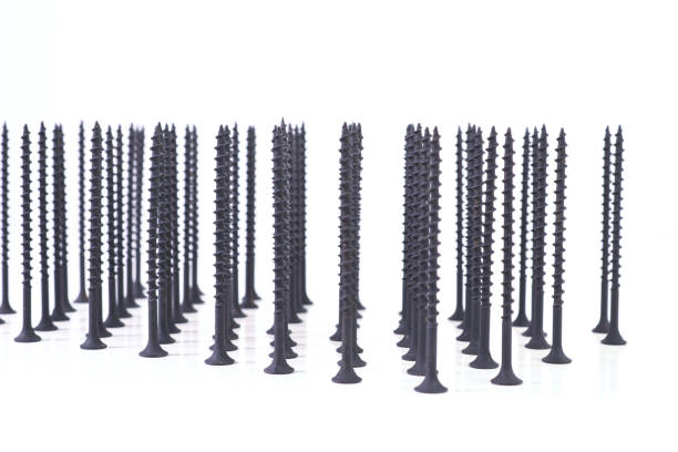 istock Self-tapping screws for wood surfaces, standing on hats, on a light background. Components for construction and repair. Metal fasteners. 1299226727