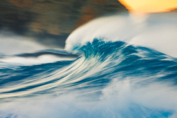 istock Cresting wave breaking with wind spray in the golden morning light 1299226920
