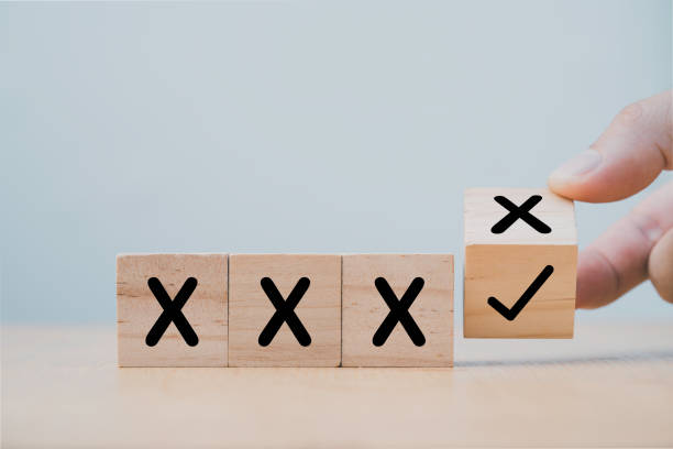 Hand flipping wooden cube block to change cross incorrect to correct mark. Hand flipping wooden cube block to change cross incorrect to correct mark. x-symbol stock pictures, royalty-free photos & images