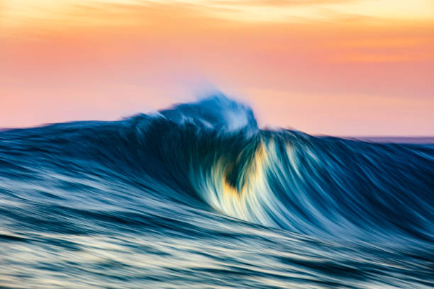 istock Cresting wave breaking in brilliant golden morning light 1299228094