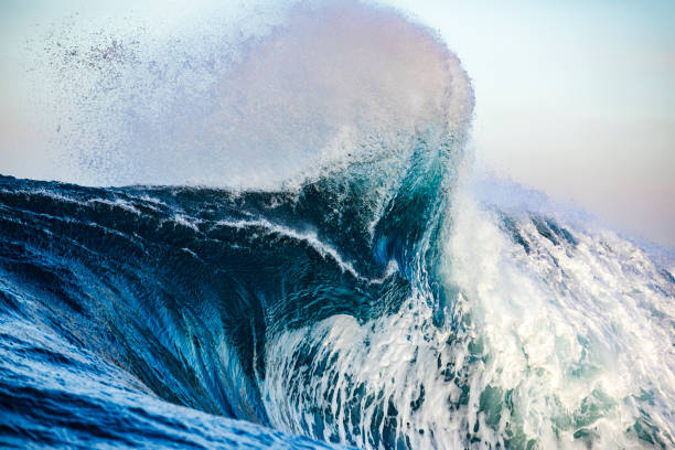 istock Powerful blue wave breaking in the open ocean in afternoon light 1299228164