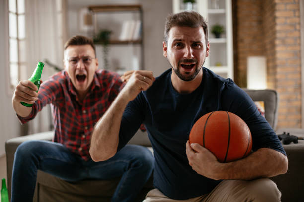 istock Men drinking beer and watching sports game on tv. 1299231856