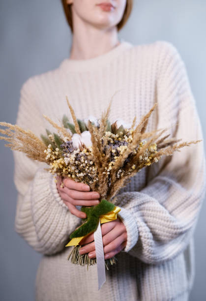 istock Girl holding dried flowers bouquet in boho style 1299232469