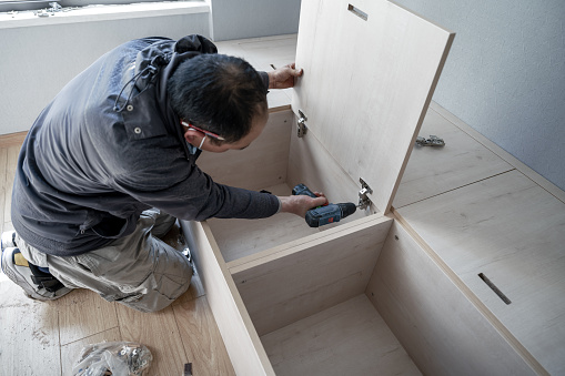 A hardworking craftsman who moved into his new apartment and was assembling cabinets