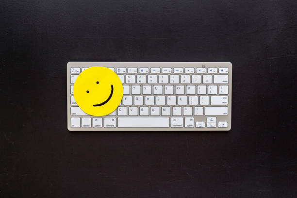 istock Smiling face emotion concept. Smile face on the keyboard, top view 1299234225