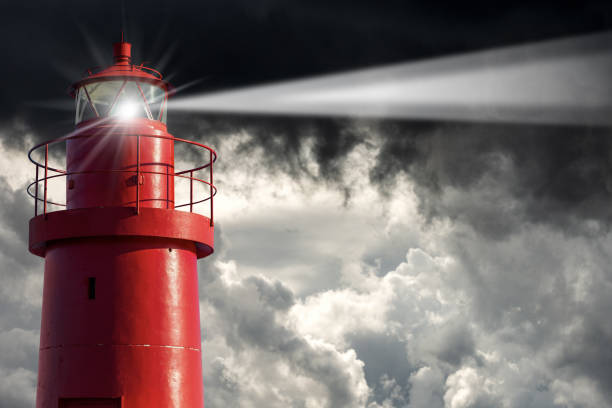 farol vermelho antigo com nuvens de tempestade no fundo - mau tempo - lighthouse beacon sailing storm - fotografias e filmes do acervo