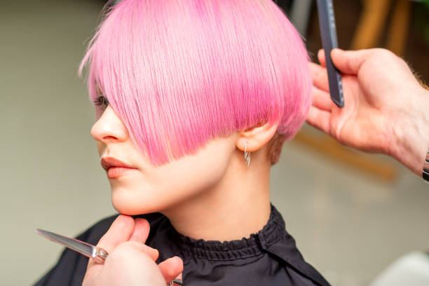 istock Hairdresser makes short pink hairstyle 1299234838
