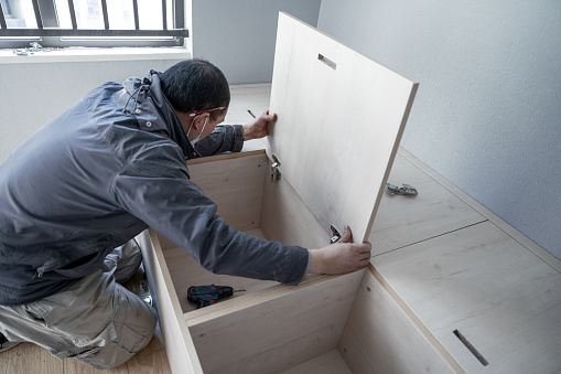 A hardworking craftsman who moved into his new apartment and was assembling cabinets