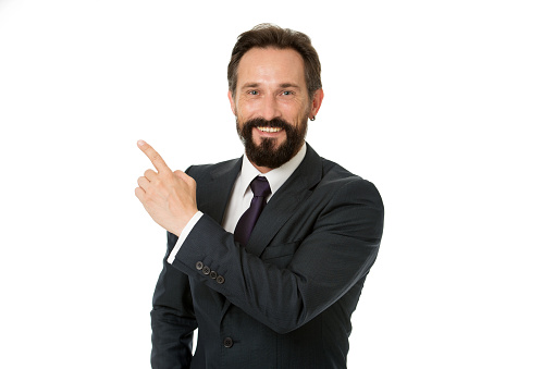 Businessman or manager shows direction. Look at that advertisement. Pointing at business advertisement. Man pointing index finger advertisement isolated on white. Man bearded mature formal suit.