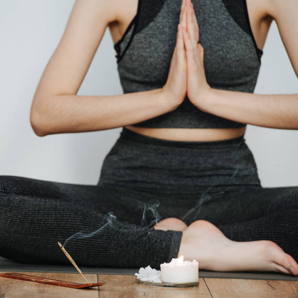istock Meditating with joined hands female instructor practicing yoga. Head cropped. 1299237859