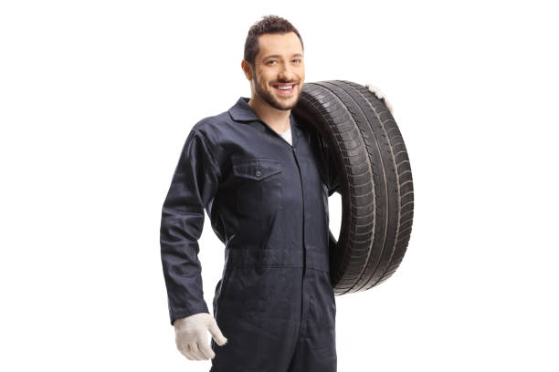 istock Mechanic holding a car tire and smiling at the camera 1299237876