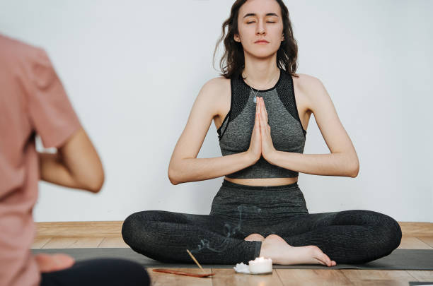 istock Serene instructor practicing yoga, meditating eyes closed. Burning incense stick 1299237897