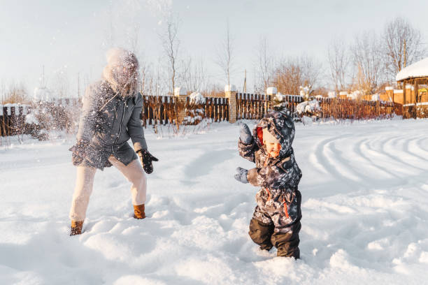 istock Happy mother and child throw snow, smiling 1299239301