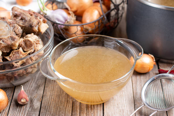 istock Bowl with beef broth, bones and fresh vegetables on a wooden table, paleo diet 1299239527