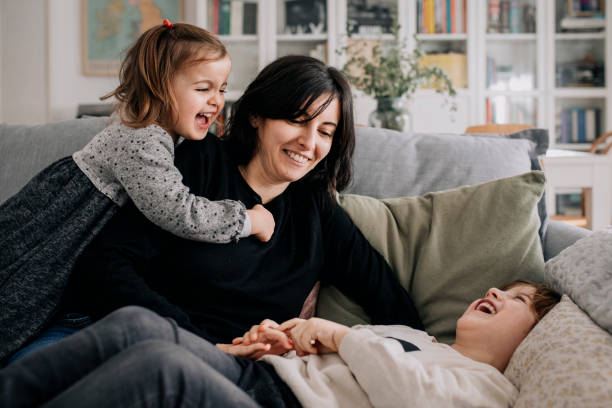 istock Mother cuddles her children at home 1299241922