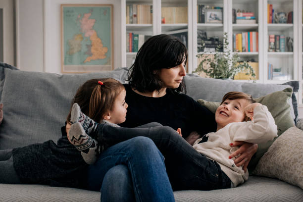 istock Mother cuddles her children at home 1299242295