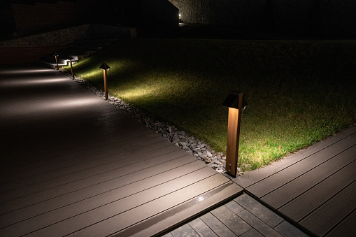 Wooden boardwalk in front of hotel illuminated with led lights