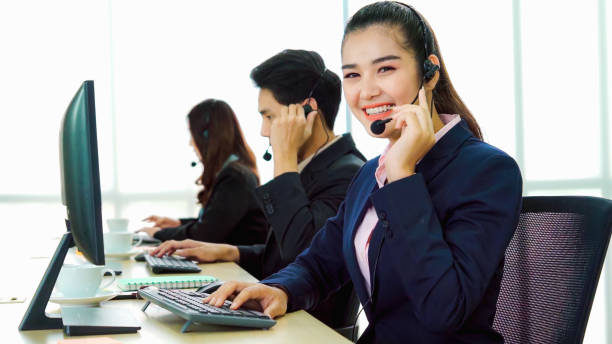 istock Business people wearing headset working in office 1299243353