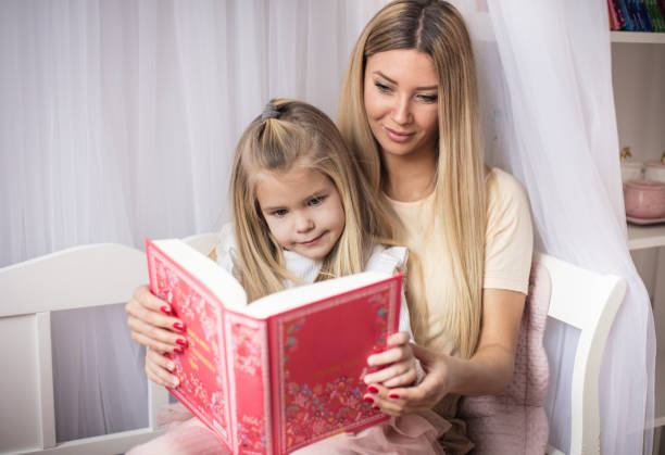 istock Mother and daughter reading book together. 1299243646