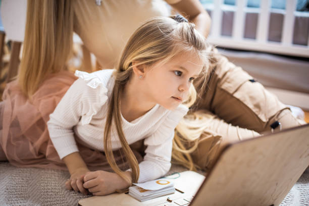 istock Mother and daughter using laptop at home. 1299244327