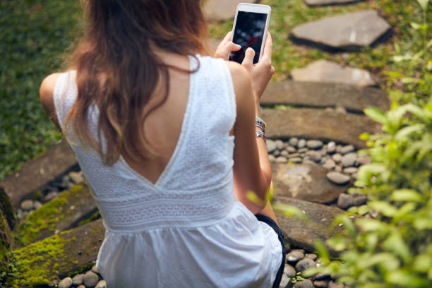 istock Caucasian young woman using modern smartphone in oriental garden. 1299244553