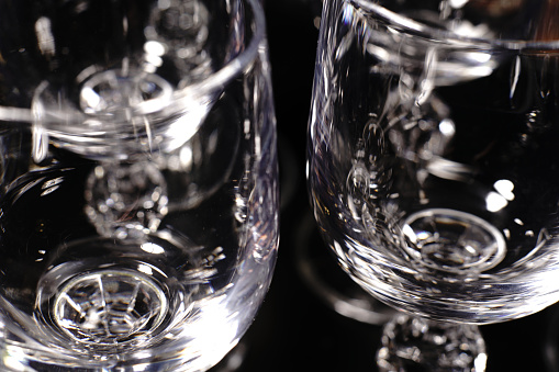 Vodka glasses on a black background. Closeup. A game of shadows.