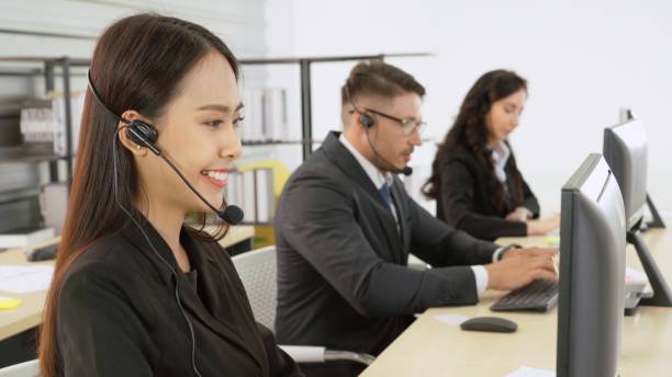 istock Business people wearing headset working in office 1299246971