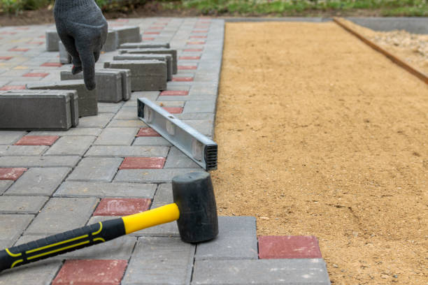 istock A builder installs concrete blocks for sidewalks in the courtyard of a country house. Selective focus. 1299247785