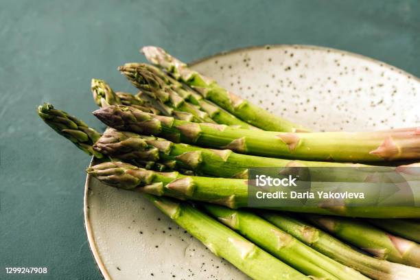Asparagus Closeup On A Plate And Green Background Stock Photo - Download Image Now - Asparagus, Green Color, Plate
