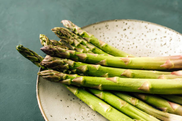 asparagus close-up on a plate and green background - asparagus imagens e fotografias de stock